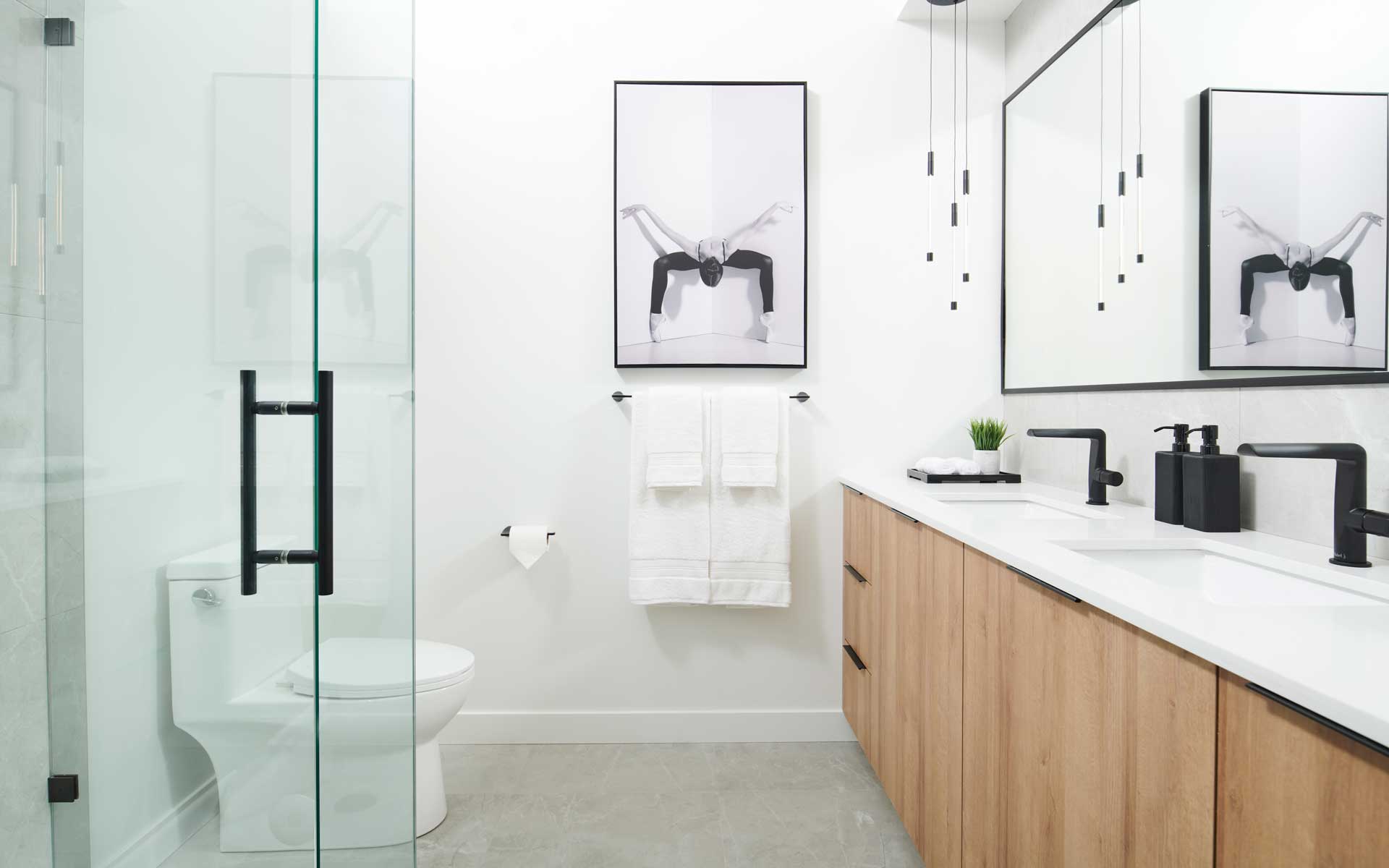 Condo bathroom with glass shower stall double vanity ceiling hung pendants and double sinks designed by KLC kre-a-tiv